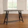 ForgeLine Console Table in Gray with a rustic wood tabletop and black trestle-style base, placed in a bright room with wooden flooring