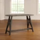 ForgeLine Console Table in Gray with a rustic wood tabletop and black trestle-style base, placed in a bright room with wooden flooring