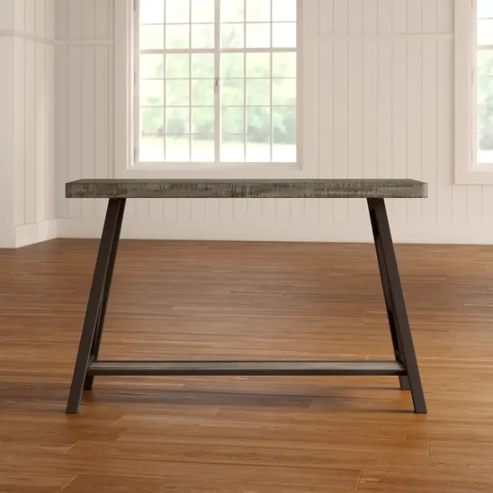 ForgeLine Console Table in Gray with a weathered wood tabletop and black angled legs, set in a bright room with wooden flooring.