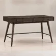 Angled front view of Script Trestle Writing Desk in Walnut finish with three-drawer storage