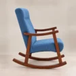 Side view of blue Aristo Rocking Chair showing high upholstered back, curved arms and long rocking runners