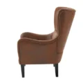 Side view of Crown upholstered wingback chair in brown faux leather with stud detailing.