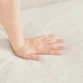 Close-up shot of a hand gently pressing into the soft fabric of the Versatile Square Arm Sofa, highlighting the cushion's comfort.