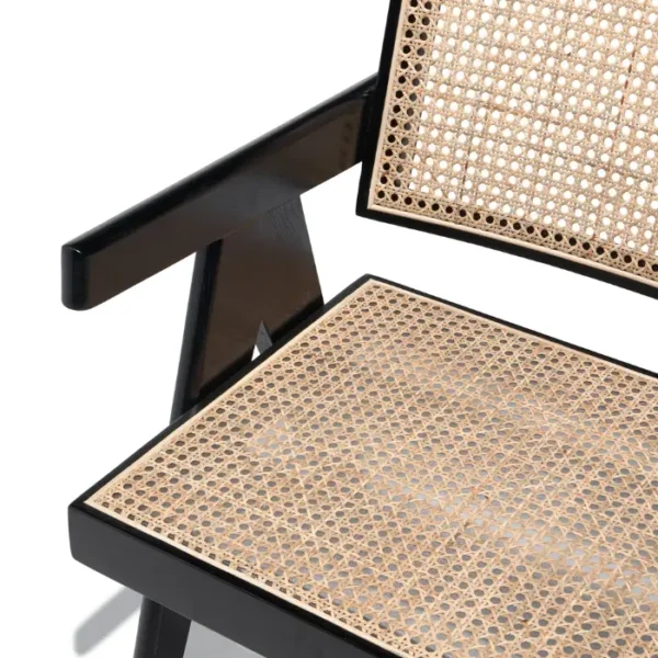 Chaya Cane Armchair close-up with woven cane seat and backrest, black wooden frame Chaya Cane Armchair close-up with woven cane seat and backrest, black wooden frame