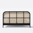 cane base of bed showing black legs