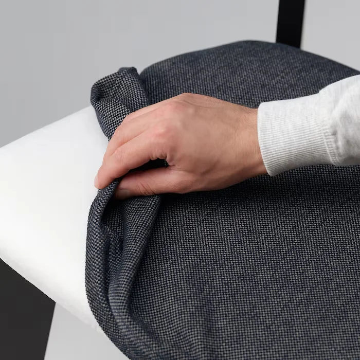 Hand adjusting removable dark grey seat cover on Roco Lisette dining chair.