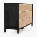 Side view of Celesté Cane Dresser with black wood frame and six woven rattan drawers