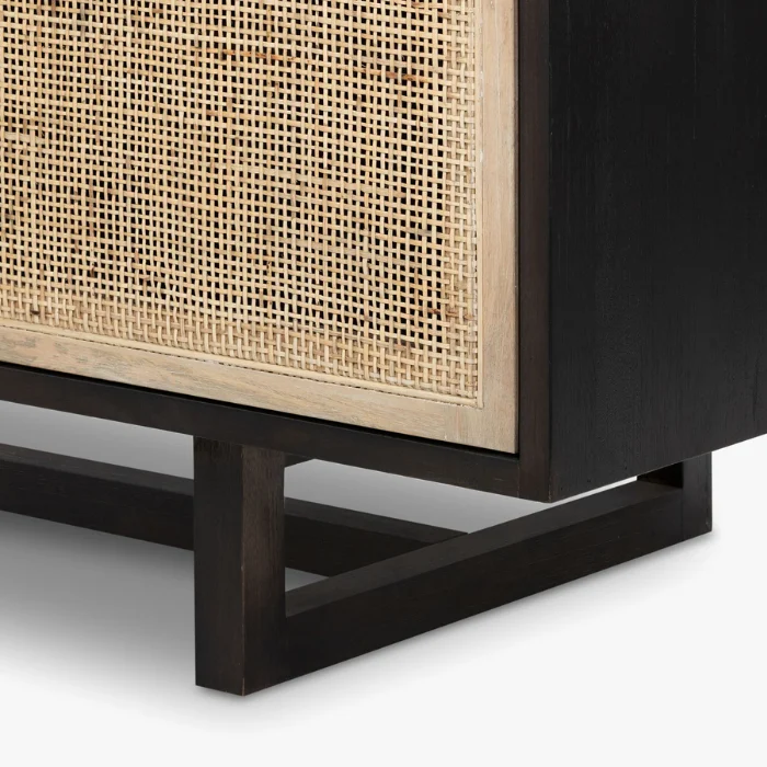 Bottom corner of Delilah Cane Desk with black wood base and woven cane panel