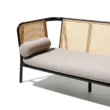 Black cane sofa with beige cushions, featuring a solid wood frame and handwoven rattan backrest