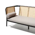 Black cane sofa with beige cushions, featuring a solid wood frame and handwoven rattan backrest