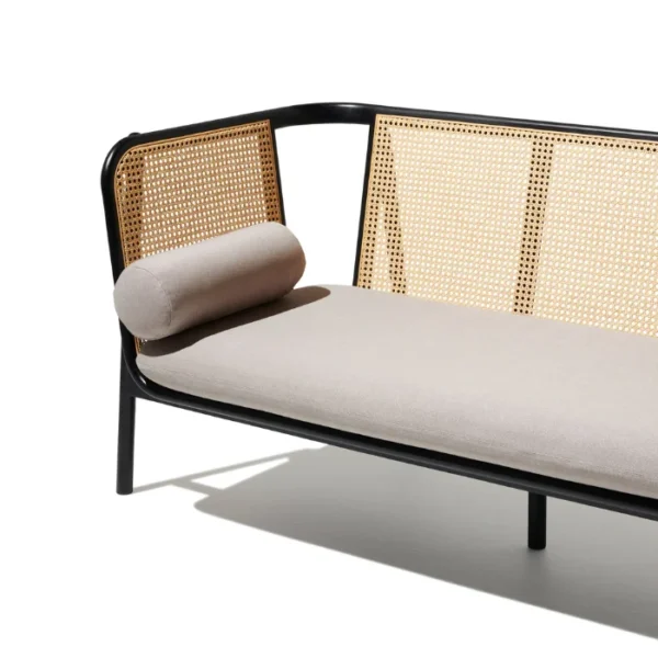 Black cane sofa with beige cushions, featuring a solid wood frame and handwoven rattan backrest Black cane sofa with beige cushions, featuring a solid wood frame and handwoven rattan backrest