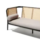 Black cane sofa with beige cushions, featuring a solid wood frame and handwoven rattan backrest