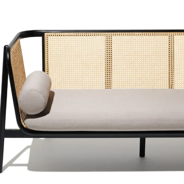 Black cane sofa with beige cushions, featuring a handwoven rattan backrest and solid wood frame Black cane sofa with beige cushions, featuring a handwoven rattan backrest and solid wood frame