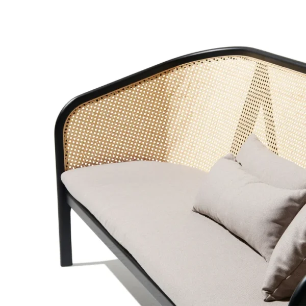 Elaila Cane Sofa – Close-up of black frame cane sofa with beige cushions and pillows Elaila Cane Sofa – Close-up of black frame cane sofa with beige cushions and pillows