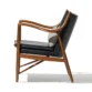 Incurve Leatherite Chair – Side view of a black leatherite lounge chair with a wooden frame and curved armrests