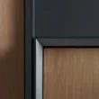Close-up of cabinet edge showing black frame and wooden panel detail.
