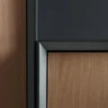 Close-up of cabinet edge showing black frame and wooden panel detail.