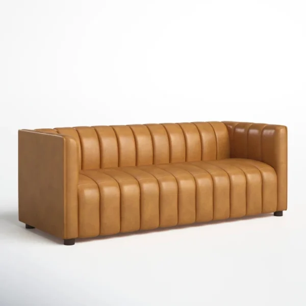 ANDERS-Sofa-Cammel-3 Angled view of camel leather-look upholstered sofa with vertical channels.