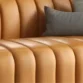 Close-up of leather upholstery showing deep fluted stitching and smooth padded texture.