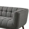 Close-up of dark grey tufted fabric sofa arm and seat with plush cushioning.