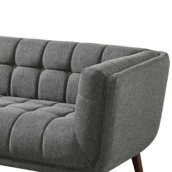 Ardrie-Upholstered-Sofa-Drak-Grey-3-1-600x600 Close-up of dark grey tufted fabric sofa arm and seat with plush cushioning.