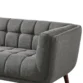 Close-up of dark grey tufted fabric sofa arm and seat with plush cushioning.