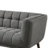 Close-up of dark grey tufted fabric sofa arm and seat with plush cushioning.