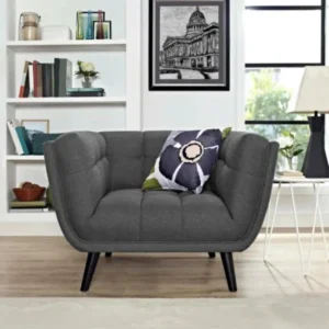 Bestow Upholstered Armchair in grey fabric with deep tufting and tapered legs styled in living room.