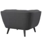 Back view of dark grey tufted armchair with smooth upholstery and tapered black mid-century legs.