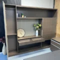 Wall storage cabinet with sliding panel open, revealing twin drawers and central display shelf.