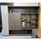 Brown wall storage unit with sliding door, open shelves, and a central display niche.
