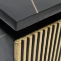 Close-up of black top with subtle bronze vein and gold fluted drawer detailing.