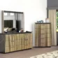 Modern bedroom scene featuring matching fluted-gold dresser and tall chest beside a window.