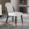 Monaco Chair in white leatherette seat with mocha back, gold trim, and black tapered wooden legs in a modern dining room setting.
