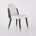Three-quarter view showing white seat, mocha backrest, and subtle gold trim on a plain background.