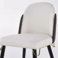 Close-up of cushioned seat and curved backrest with neat stitching and gold under-frame detail.