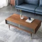 Living room scene with walnut coffee table, fluted glass doors, brass-capped legs, blue sofa.