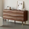 Nordic Haven Dresser – angled view of wooden dresser with wave-textured drawers and brass-accented legs.