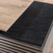 Close-up of contrasting oak wood and slate black desktop surfaces.