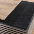 Close-up of contrasting oak wood and slate black desktop surfaces.