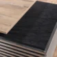 Close-up of contrasting oak wood and slate black desktop surfaces.