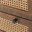 Detailed shot of cane drawer front with round black knob.