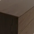 Oslo Side Table – close-up view showing smooth closed edge and detailed wood grain texture on the brown wooden surface.