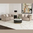 Two curved loveseats arranged in an L-shape around a black-and-gold round coffee table in a bright living room.