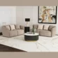 Two curved loveseats arranged in an L-shape around a black-and-gold round coffee table in a bright living room.