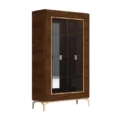 Walnut veneer display cabinet with glass doors, light trim, and slim metallic legs—angled view.