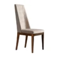 Three-quarter view of a beige high-back dining chair with channel-tufted backrest.