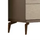 Lower corner close-up highlighting ribbed drawers and tapered metal legs in warm bronze finish.