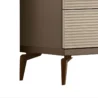 Lower corner close-up highlighting ribbed drawers and tapered metal legs in warm bronze finish.
