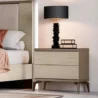 Verona Side Table with ribbed cream drawers, slim metal legs and dark top beside bed with lamp